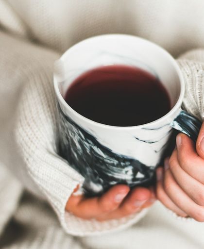 Hands holding a warm mug of tea